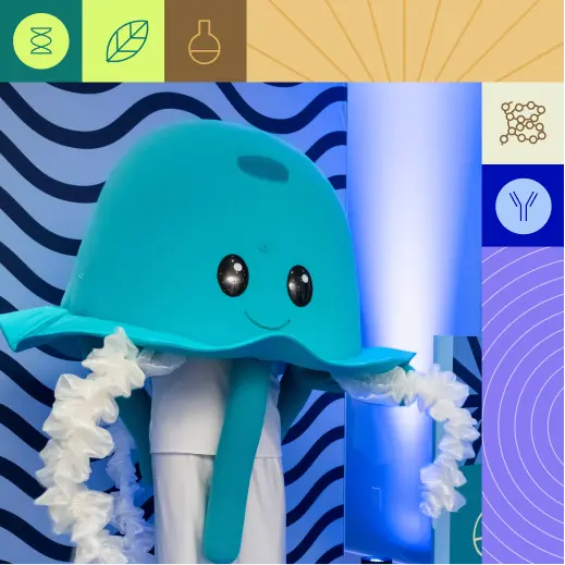 Blue jellyfish mascot with a large turquoise hat and white ruffled scarf posing in a bright, geometric backdrop.